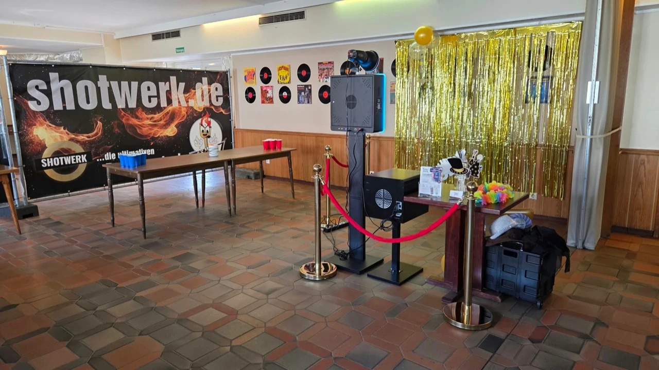 Aufgebaute FokusKiste mit Fotodrucker, Requisiten und goldenem Hintergrund bei einer Veranstaltung